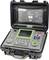 Un appareil de mesure électrique portable ouvert dans un coffret robuste, avec des boutons de commande, un écran et un mode d'emploi dans le couvercle.