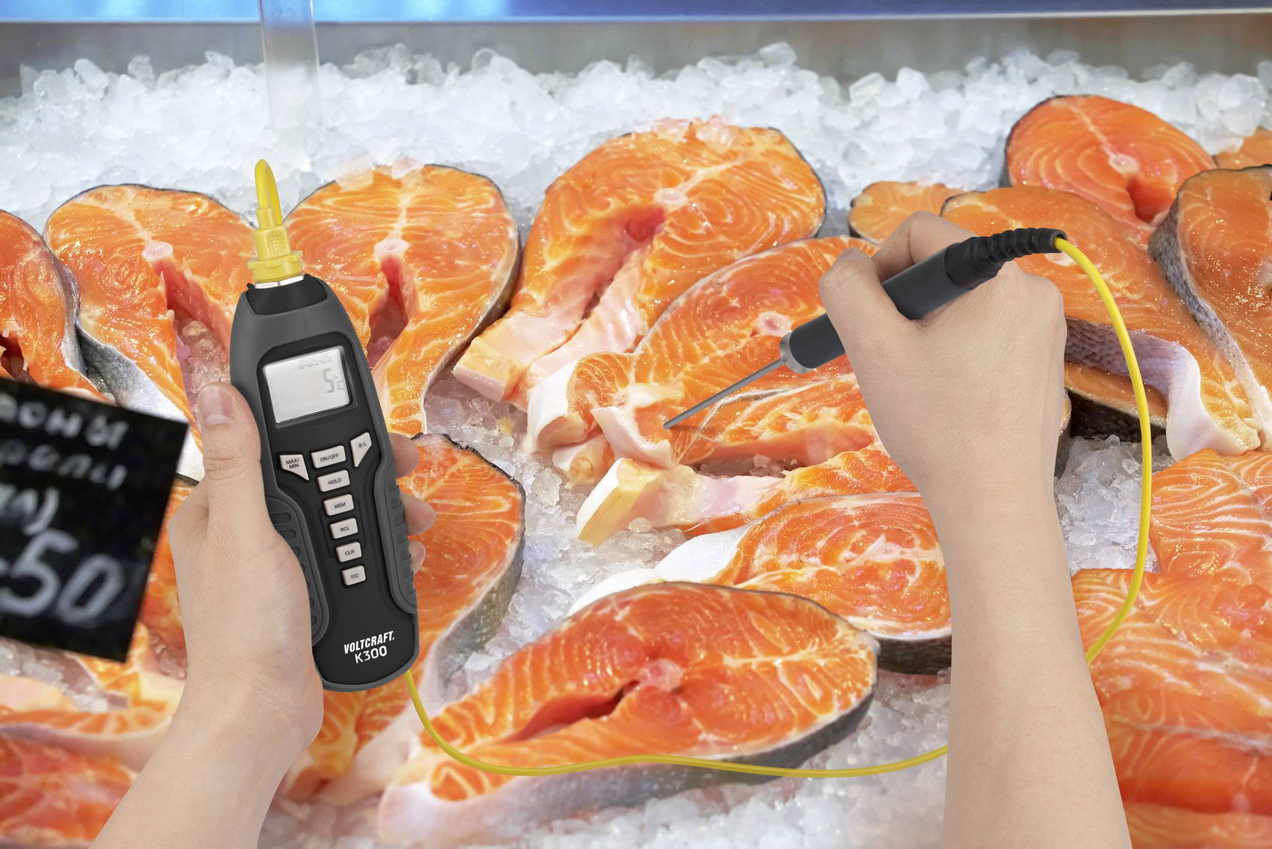 Une main mesure la température du saumon cru à l'aide d'un thermomètre numérique sur de la glace, afin de vérifier sa fraîcheur.