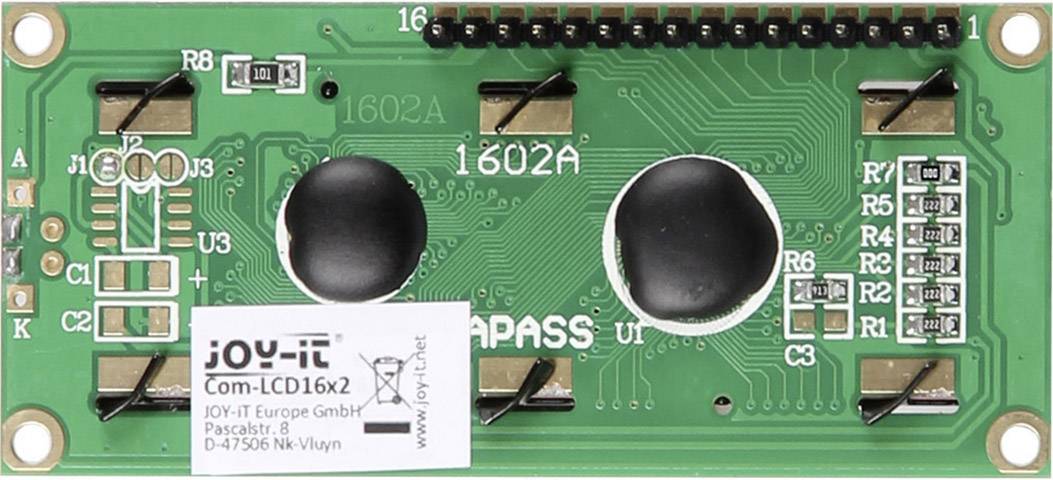 Carte LCD verte avec des broches noires et des circuits imprimés. Texte '1602A'. Étiquette du fabricant 'JOY-IT' avec adresse et numéro de modèle.