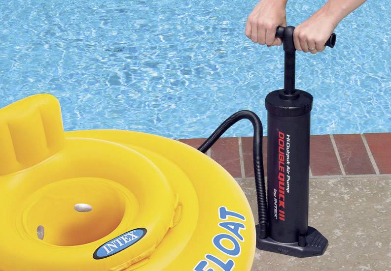 Une personne gonfle un bouée jaune avec une pompe manuelle au bord d'une piscine.