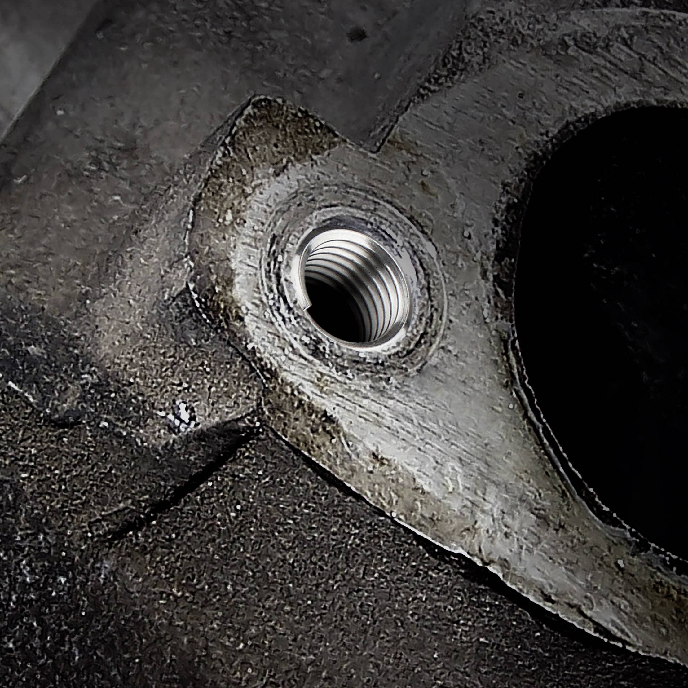 Gros plan d'un trou fileté dans une pièce métallique, permettant une connexion ou une fixation.