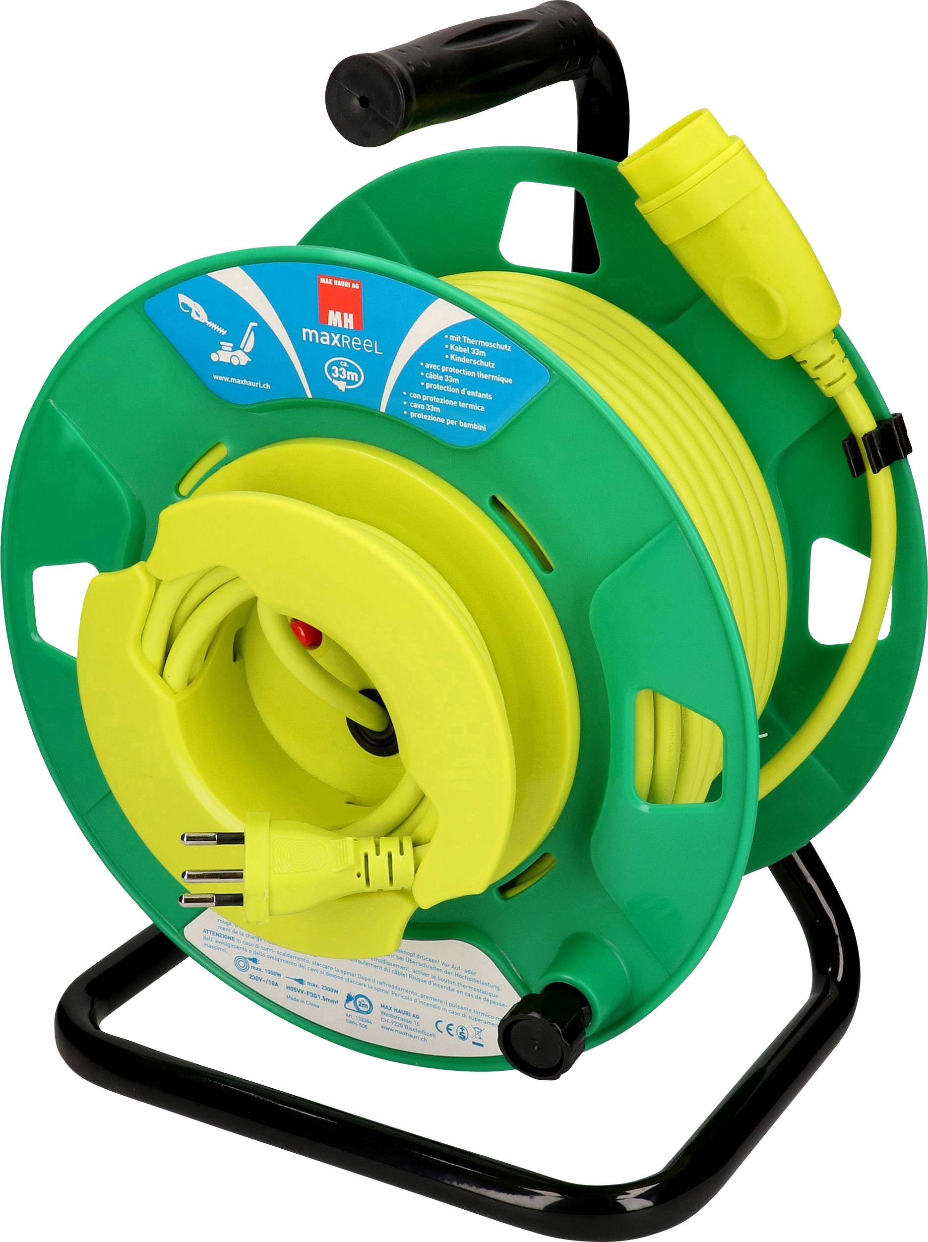 Bobine de câble verte avec une rallonge jaune et des fiches électriques, posée sur un support noir.