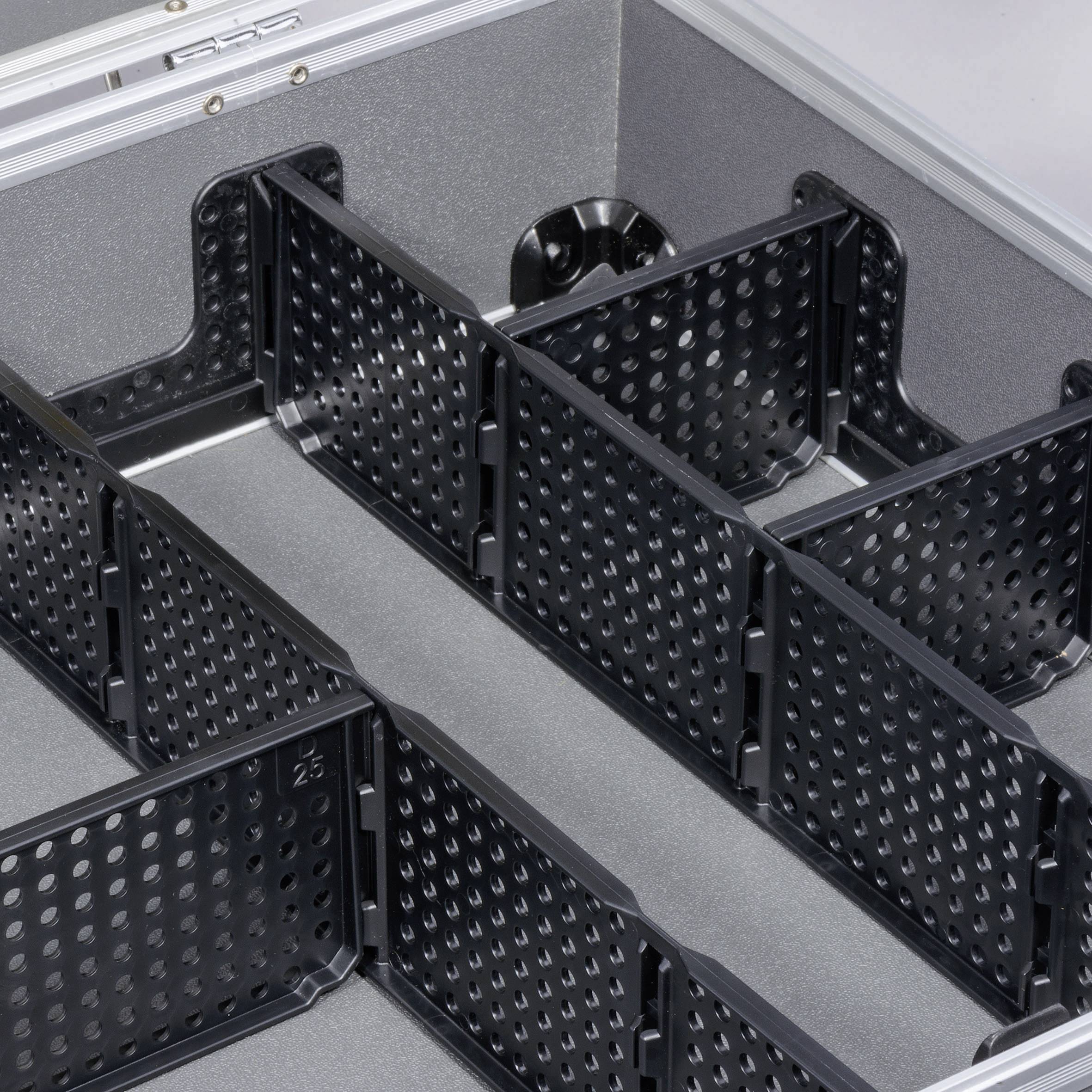 Une valise ouverte avec plusieurs compartiments ajustables, séparés par des cloisons noires perforées.