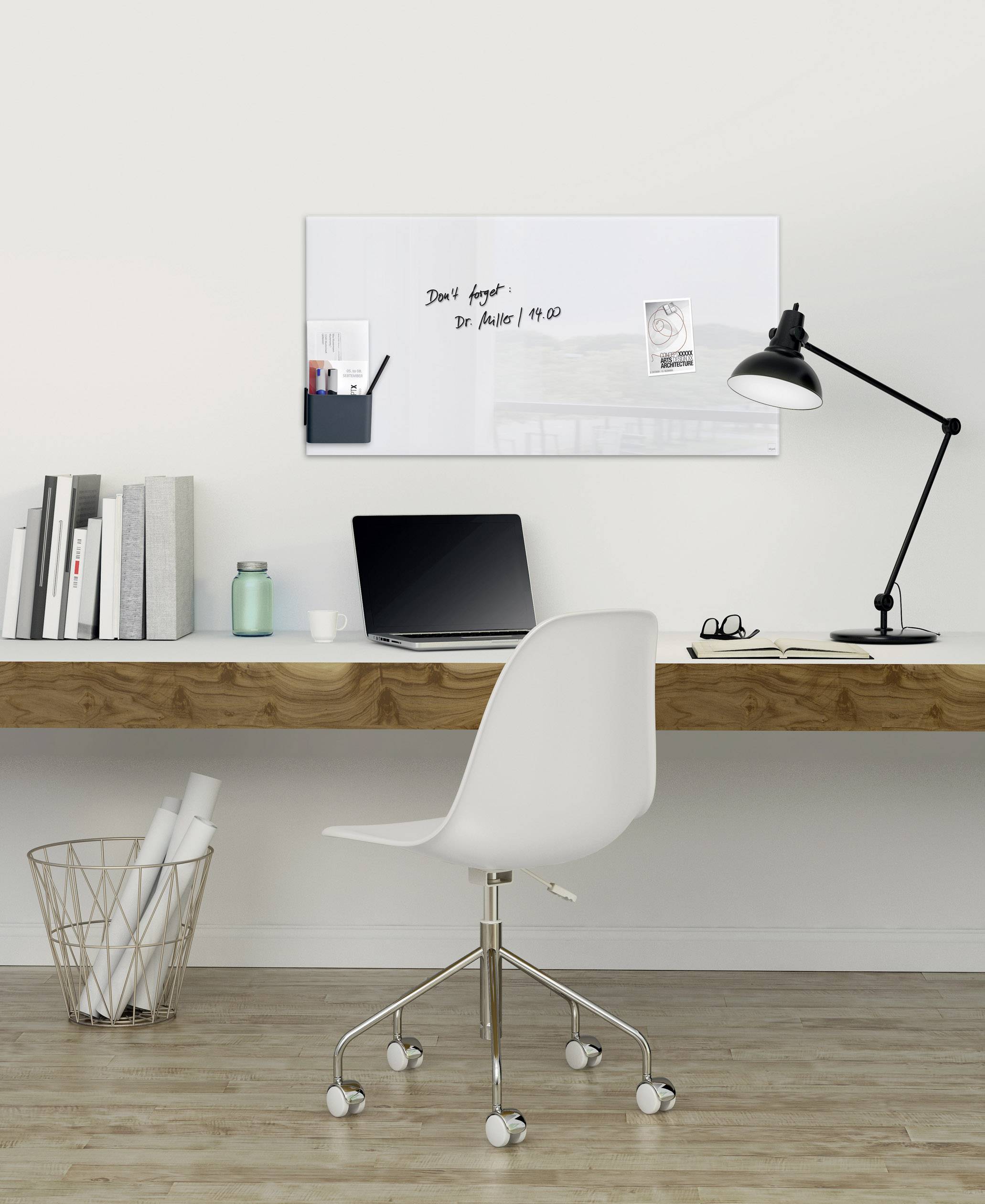 Un espace de travail minimaliste avec un bureau blanc, un ordinateur portable, une lampe, des livres et un tableau blanc couvert de notes.