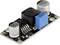 Module électronique avec vis de potentiomètre bleue, deux condensateurs argentés et une bobine d'inductance noire, utilisé dans les circuits électroniques.