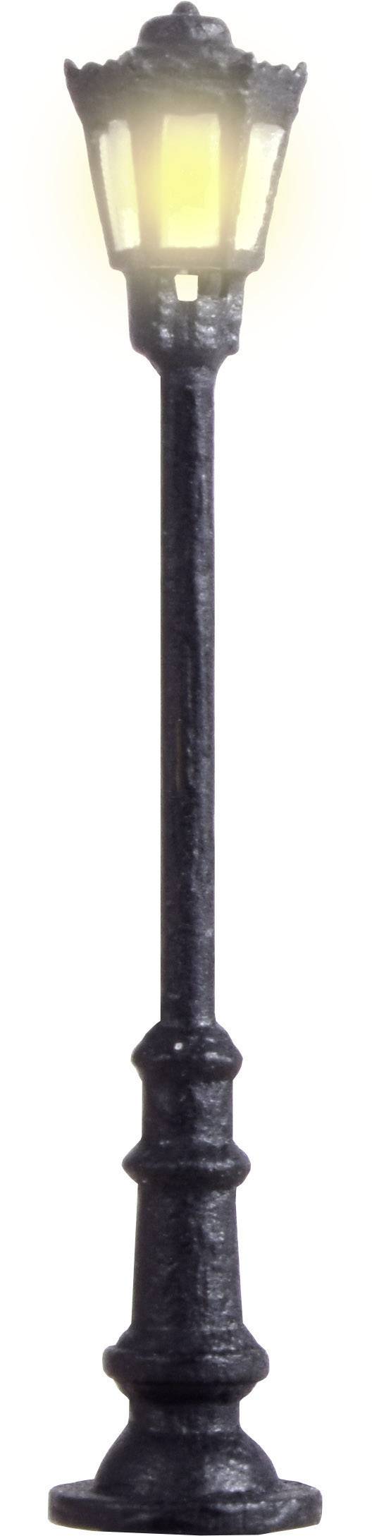 Un lampadaire ancien solitaire, émettant une lumière chaude et douce, se dresse devant un arrière-plan neutre.