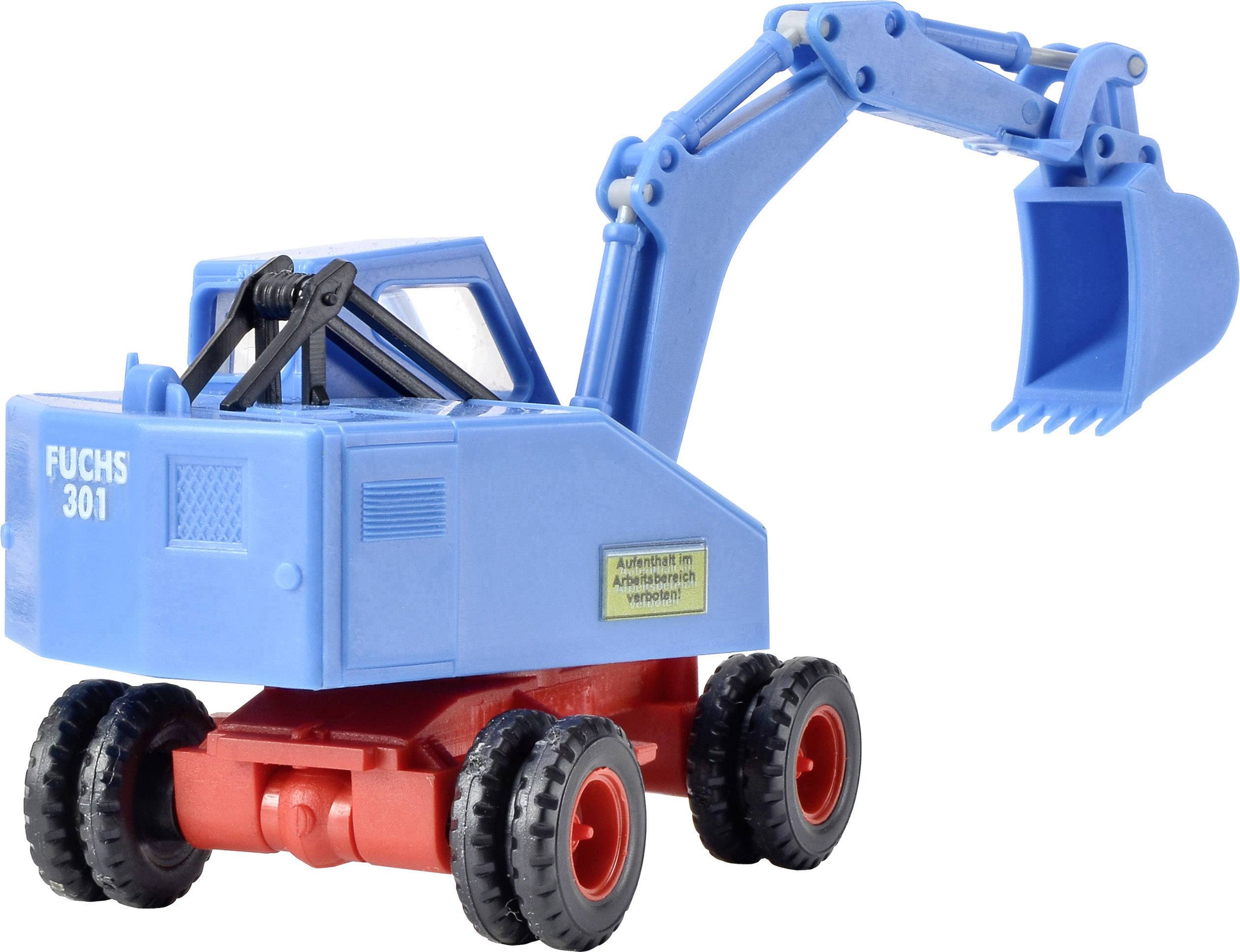 Pelle mécanique bleue et rouge portant l'inscription « Fuchs 301 ». Le bras avec la pelle est levé. Un autocollant indicatif est visible.