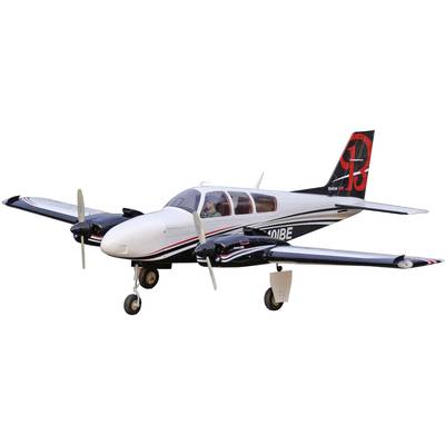 Un avion bimoteur blanc et noir avec un logo rouge sur la dérive vole dans le ciel.