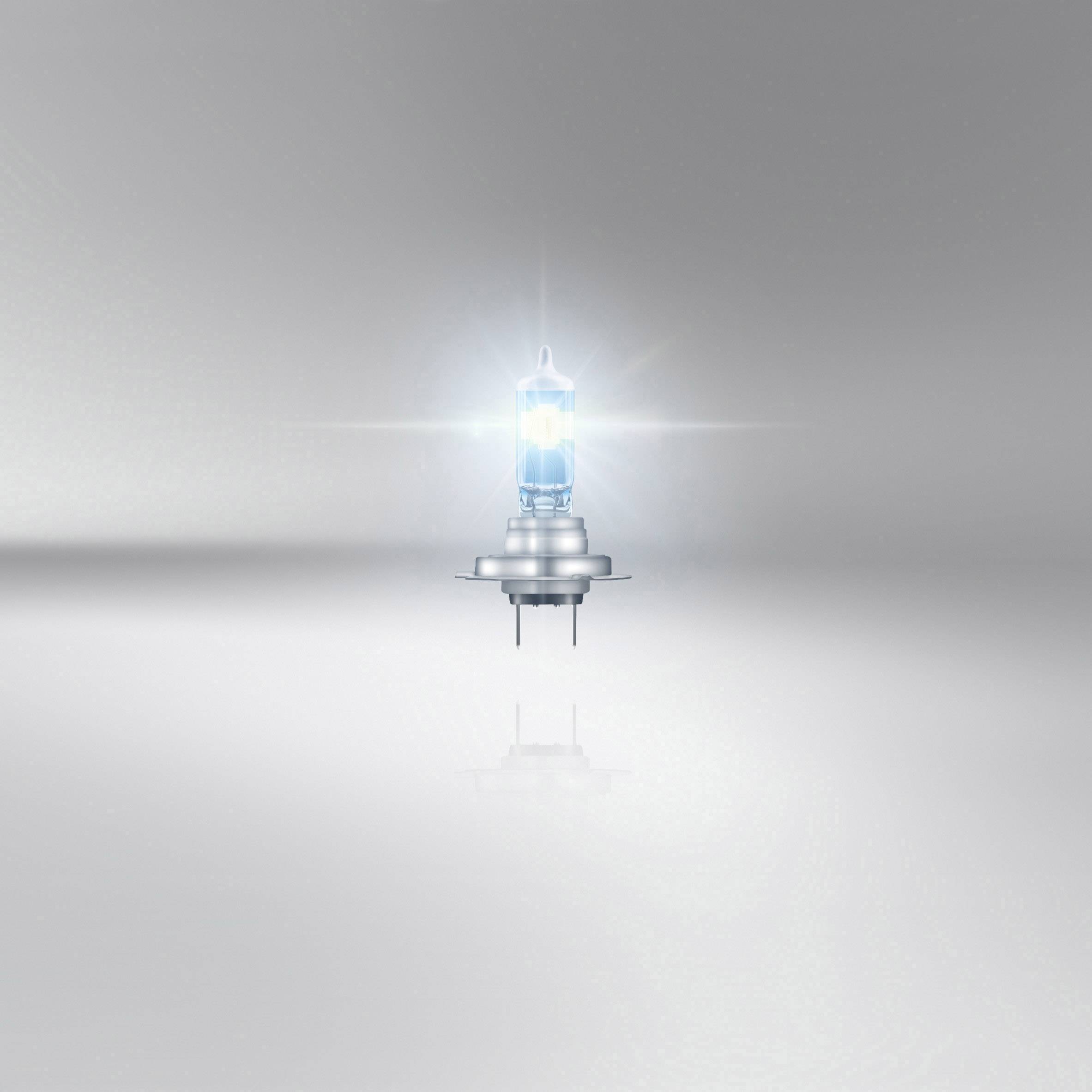 Une unique lampe halogène lumineuse au centre de l'image, dotée d'un socle argenté, entourée d'un arrière-plan gris et flou.