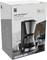 Emballage d'une machine à café WMF KITCHENminis Aroma avec carafe en verre et Cromargan. L'image montre la machine et des tasses à café sur une table.