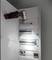 Un armoire électrique ouverte avec plusieurs fusibles et un interrupteur. Une lampe de poche est braquée sur l'armoire électrique.