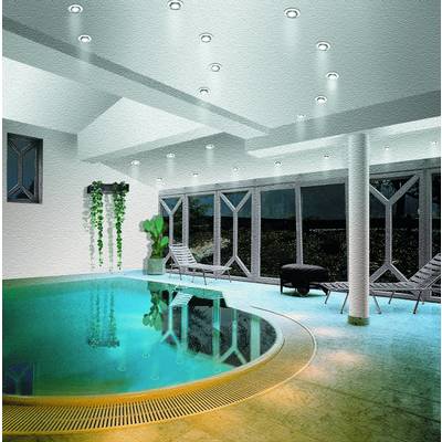 Un intérieur luxueusement conçu avec une piscine ronde, un éclairage moderne et de grandes fenêtres donnant sur l'extérieur.