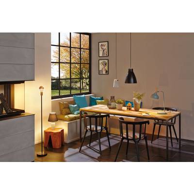 Espace repas avec une table en bois, quatre chaises et un banc devant une grande fenêtre. Des lampes suspendues au-dessus de la table. Décoration : plantes, vases.