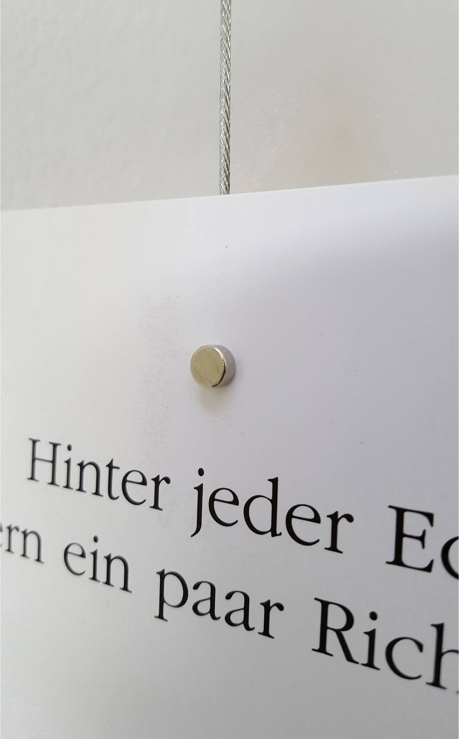 Panneau blanc sur le mur avec la phrase 'Derrière chaque coin se cachent quelques directions'.