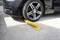 Une voiture avec une roue avant immobilisée est garée sur une barrière jaune qui empêche toute poursuite du trajet.