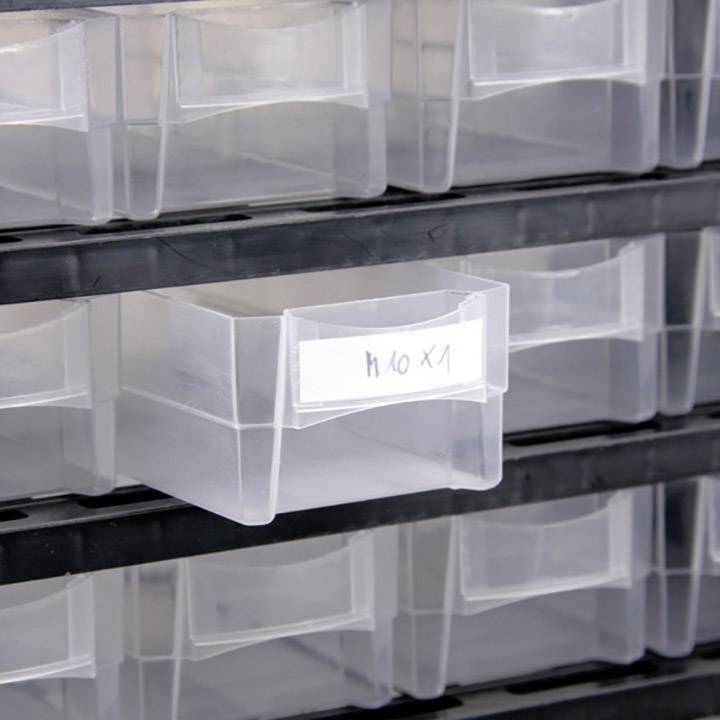 Tiroirs en plastique dans une étagère. Un tiroir est partiellement ouvert et porte une étiquette manuscrite indiquant 'H10 x1'.