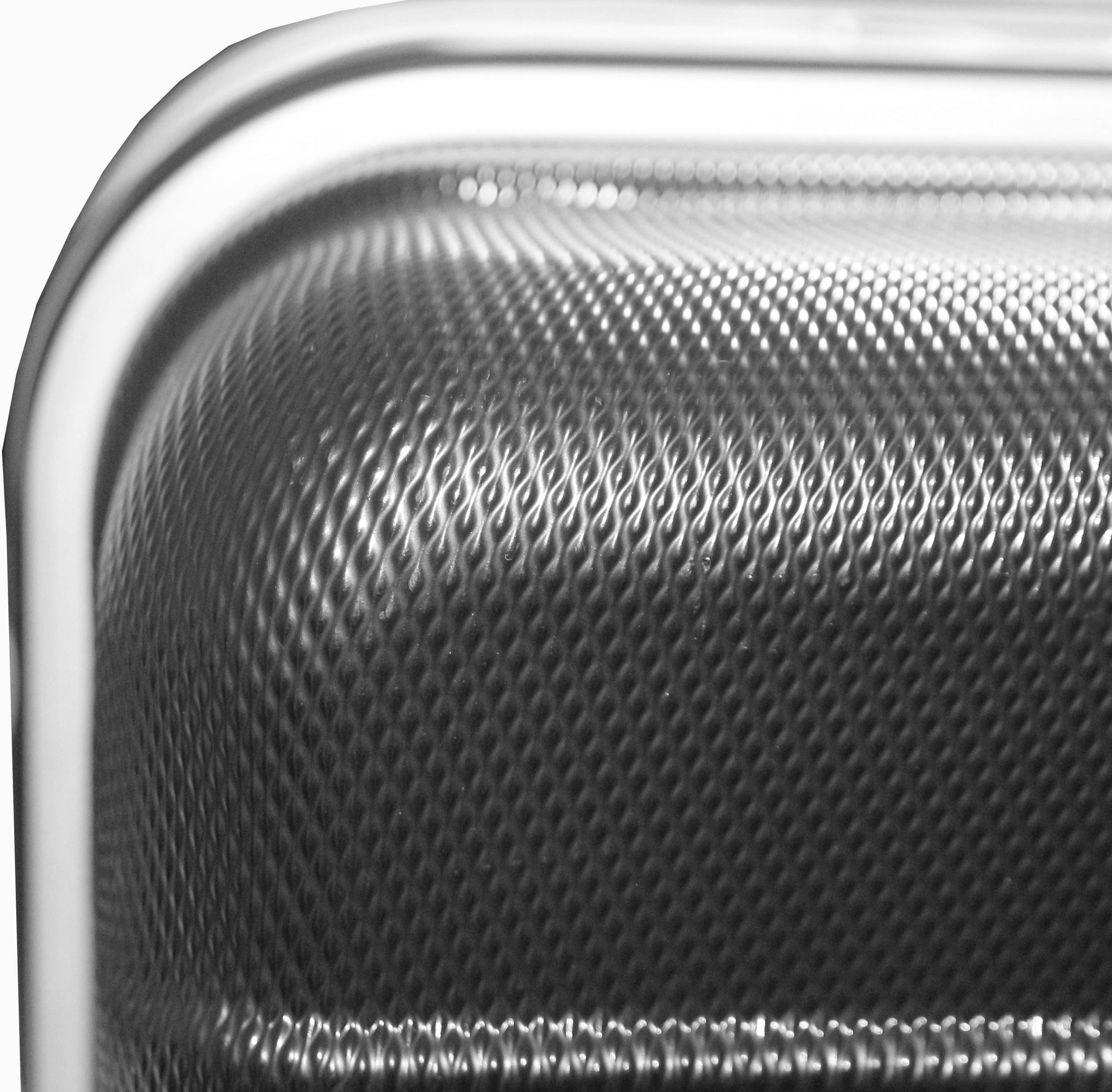 Un gros plan d'un objet métallique structuré avec des courbes et des reflets lumineux, révélant les fins détails de sa surface.