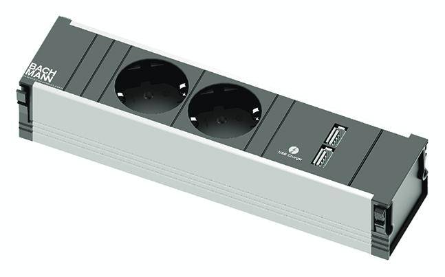 Prise double avec deux ports USB dans un cadre rectangulaire. Nom de marque 'Bachmann' en haut à gauche.