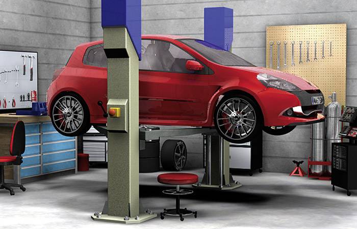 Une voiture rouge sur un pont élévateur dans un atelier de réparation automobile. À l'arrière-plan, on aperçoit des armoires à outils et un établi.