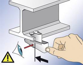 Une main utilise un outil pour mesurer un objet. Symbole d'avertissement pour la prudence et la protection des yeux.