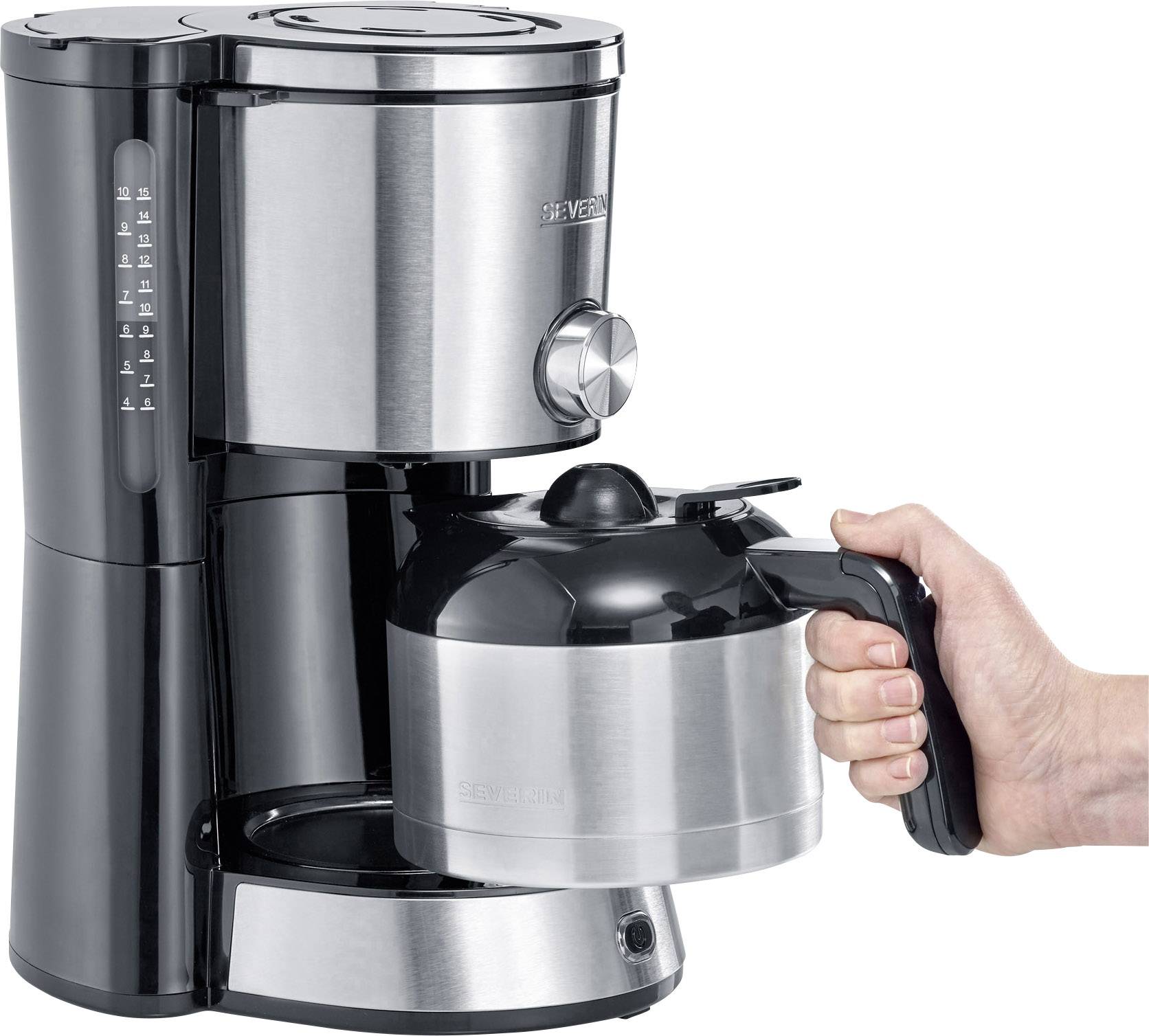 Machine à café argentée avec une poignée noire. Une main tient la carafe en verre avec un couvercle et une anse noirs.