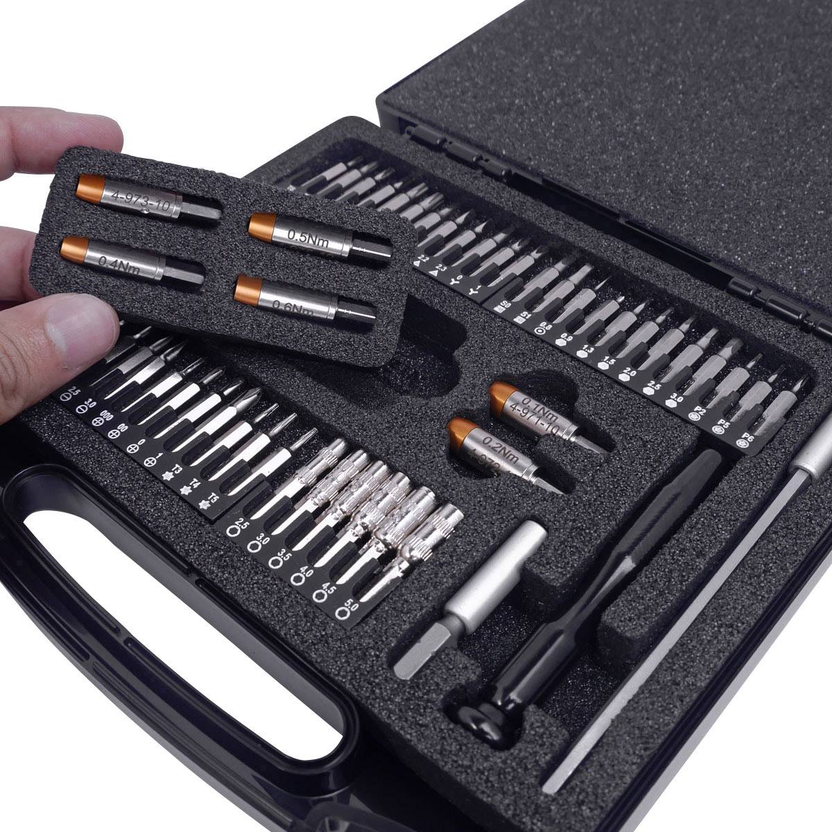 Une mallette à outils ouverte contenant différents embouts et manches de tournevis. Une main tient un insert en mousse avec des embouts.