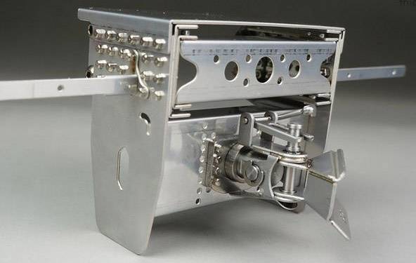 Appareil mécanique métallique avec des leviers et des compteurs, probablement un composant d'une machine ou d'un dispositif complexe.