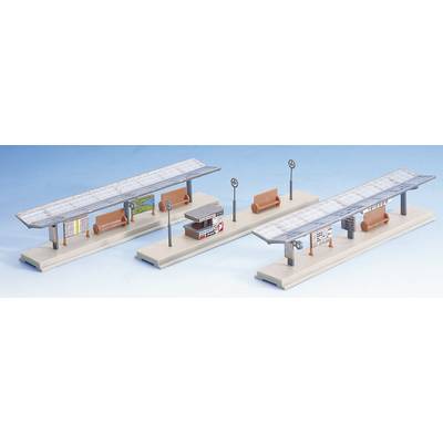 Modèles de quais miniatures avec auvents, bancs et panneaux indicateurs. Deux plateformes avec des petits éléments, représentées dans un environnement clair.