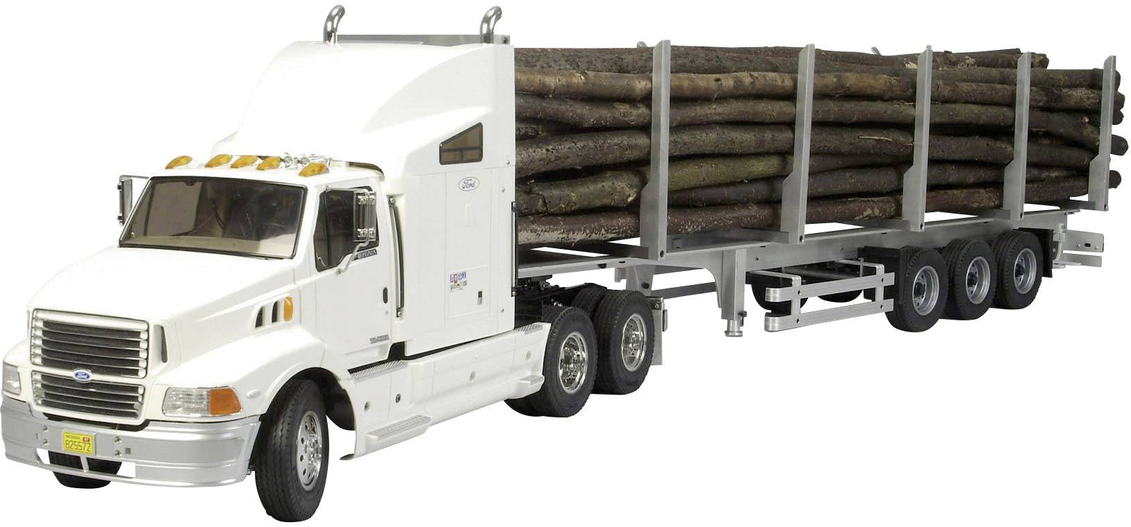 Un camion blanc transporte des grumes sur une remorque à trois essieux.