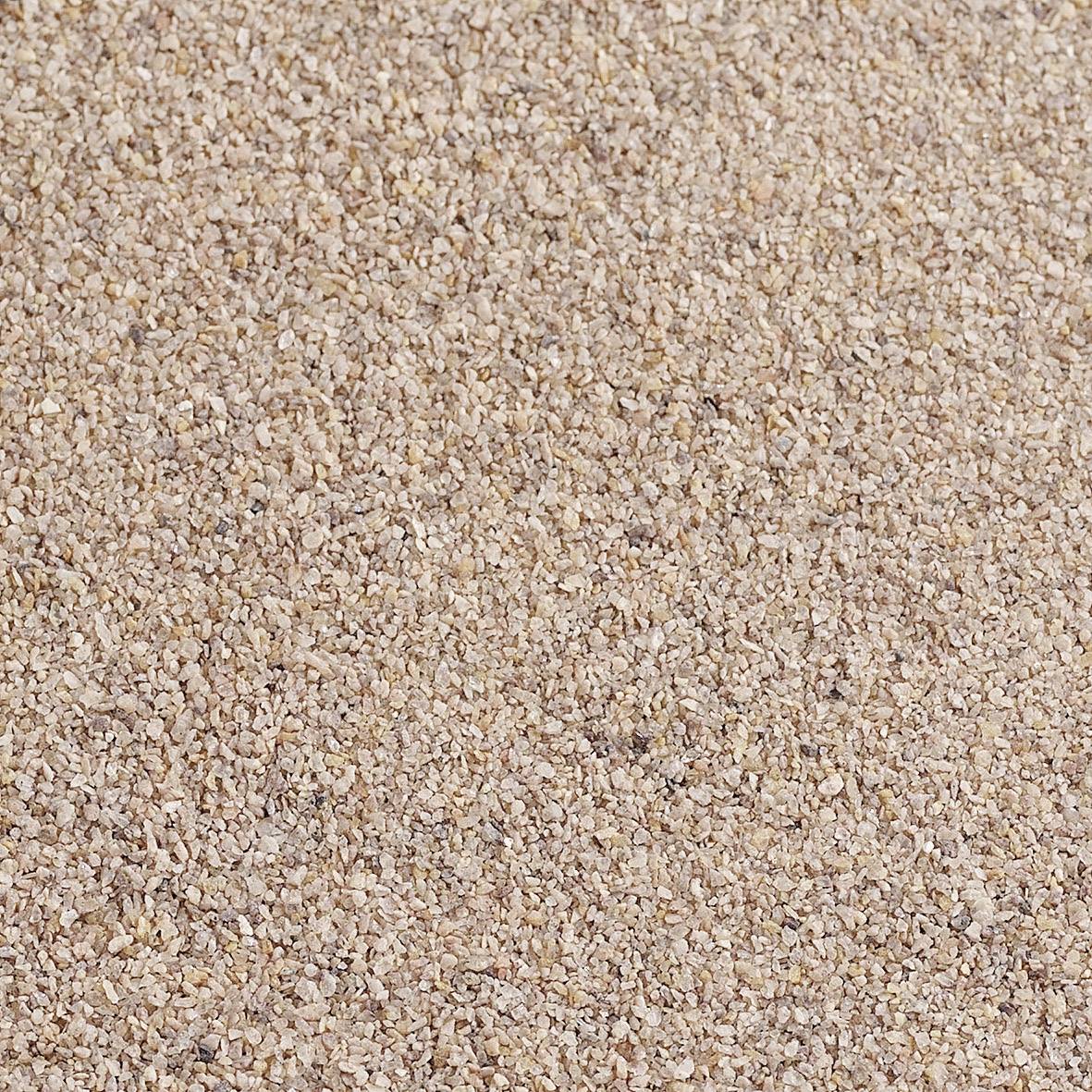Un gros plan de petits cailloux ou de gravier répartis uniformément révèle une texture sableuse.