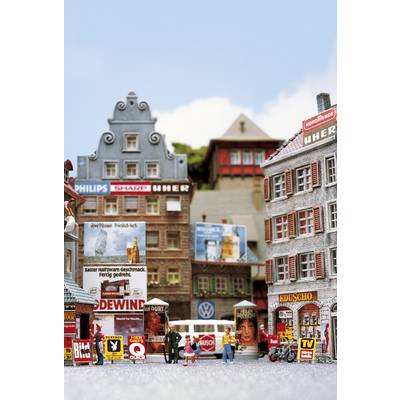 Une scène de ville miniature avec des bâtiments miniatures, des panneaux publicitaires et de petites figurines. Certains bâtiments sont décorés avec des enseignes de marques connues.