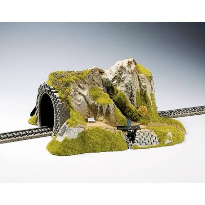 Un tunnel de chemin de fer miniature avec des rails, entouré de rochers et de végétation.