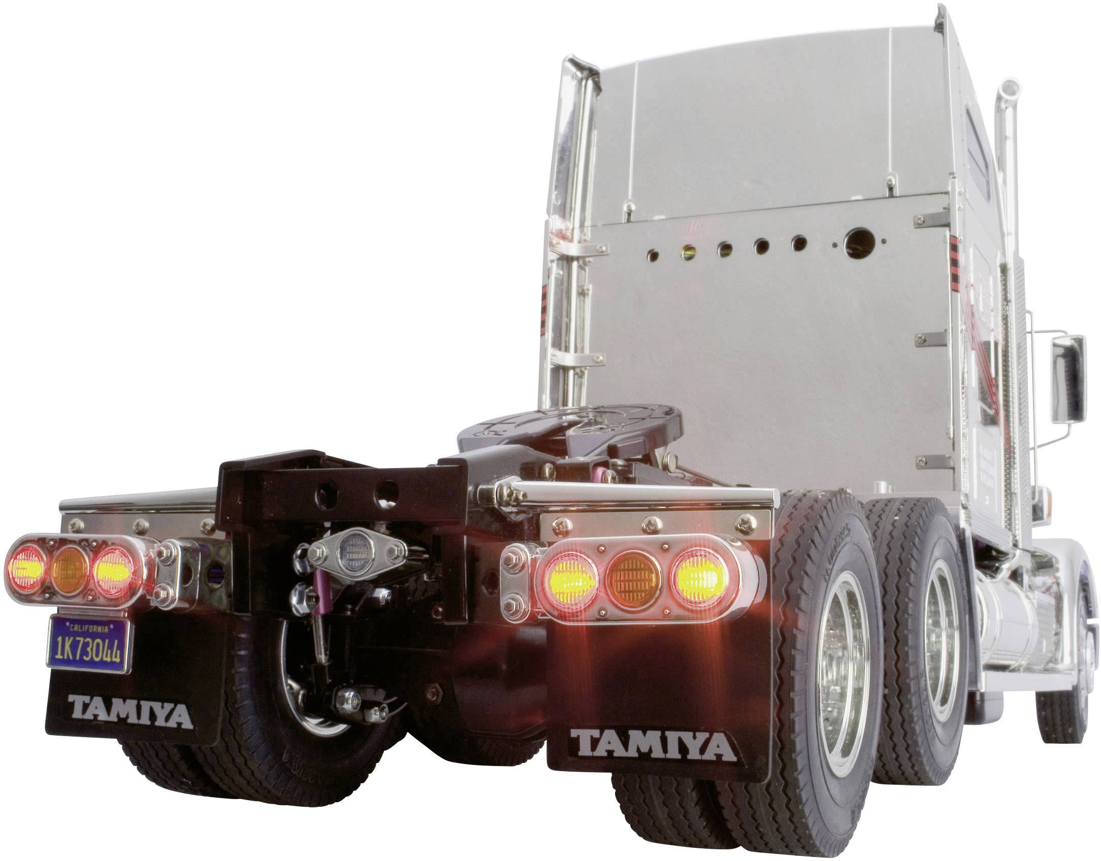 Un camion-modèle argenté de Tamiya avec des feux arrière lumineux, reconnaissable à l'étiquette de marque sur les garde-boue.