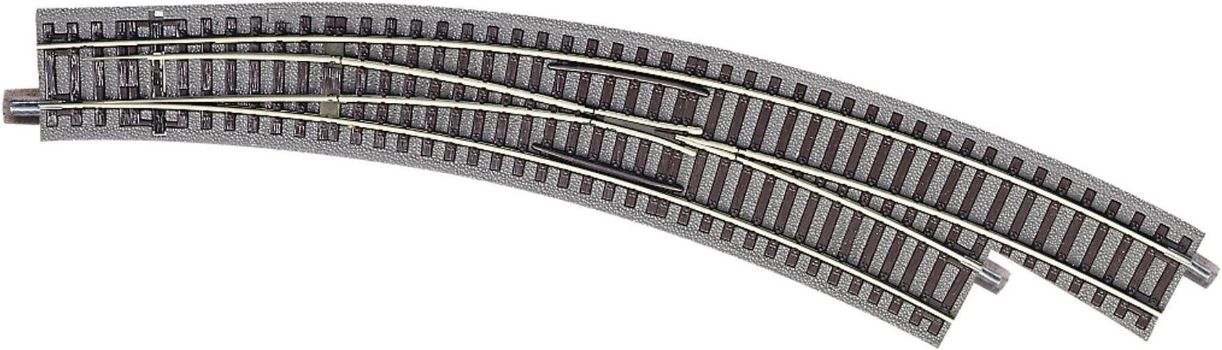 Système ferroviaire miniature avec deux voies parallèles incurvées et un aiguillage permettant de changer de direction.