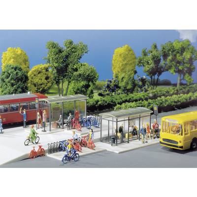 Un diorama représente une gare animée de bus et de vélos. Des personnes attendent des bus, rangent leurs vélos et se déplacent çà et là.