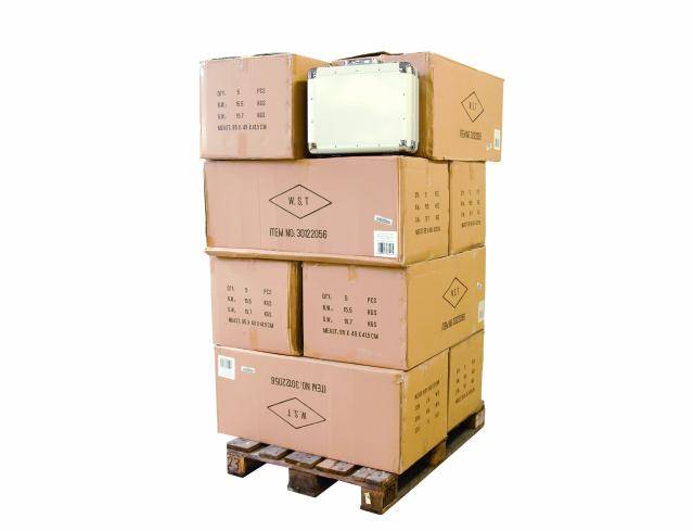 Une pile de cartons d'emballage bruns sur une palette en bois. Les boîtes sont imprimées avec des informations sur le produit et prêtes à être livrées.