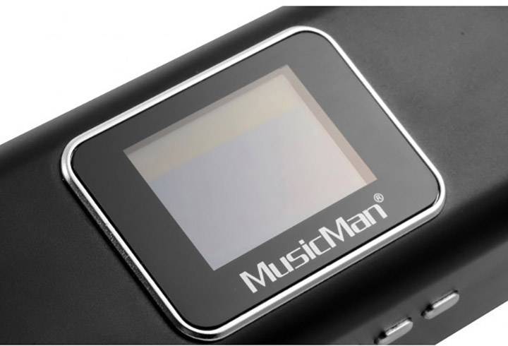 Appareil électronique avec un petit écran et le logo 'MusicMan' en dessous. Deux boutons latéraux sont situés sous ce logo.