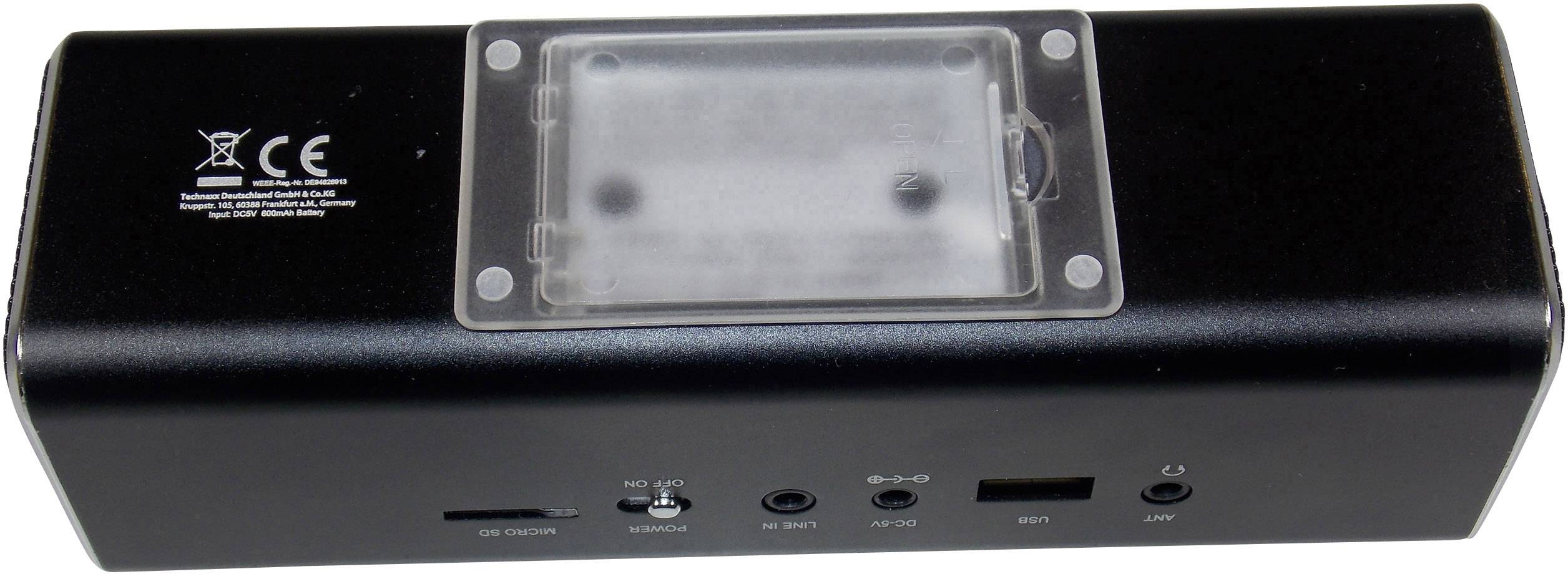 Appareil électronique noir vu de dos avec plusieurs ports : logement pour carte SD, USB, audio et port de charge. Compartiment transparent en haut.