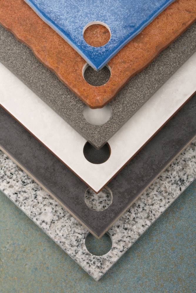 Six carreaux rectangulaires de différentes couleurs et textures, empilés de manière décalée les uns sur les autres, avec des découpes circulaires dans un coin.