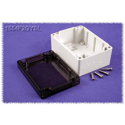 Une boîte de dérivation en plastique grise et noire sur un fond lilas, avec quatre vis à côté.