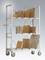 Étagère métallique sur roulettes avec quatre niveaux, permettant le stockage de cartons et d'enveloppes de différentes tailles pour l'expédition.