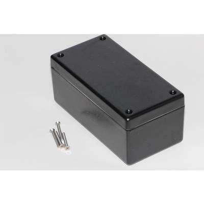 Boîtier en plastique noir rectangulaire aux coins arrondis, à côté de quatre vis argentées sur une surface blanche.