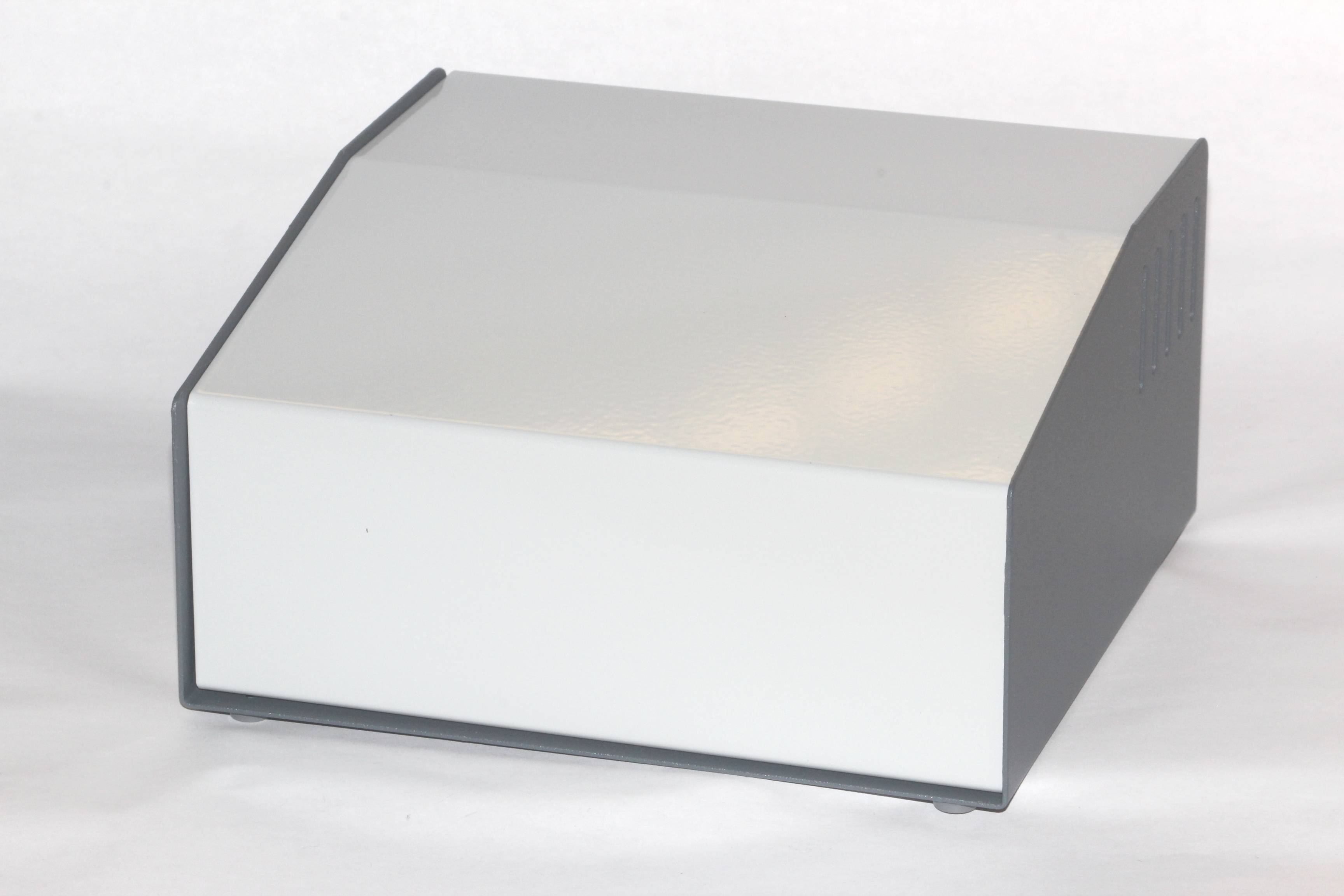 Boîtier rectangulaire en plastique gris avec un dessus biseauté et une texture lisse, sur fond blanc.