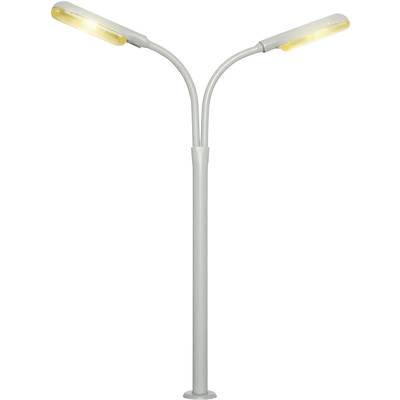 Lampadaire argenté moderne avec deux bras courbés vers l'extérieur et des lampes LED émettant une lumière chaleureuse.