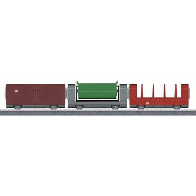 Wagons de train miniature : Un wagon box marron, un wagon gris avec un conteneur vert, et un autre wagon de marchandises rouge sur la voie.