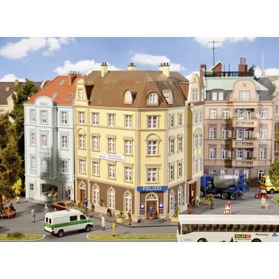 Une scène de rue animée représente une ville miniature avec un poste de police au centre, entouré de bâtiments et de véhicules colorés.