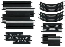 Plusieurs pièces de route de jouet noires de différentes formes : des segments droits, des courbes et des tronçons d'intersection. Elles sont modulaires et s'emboîtent les unes aux autres.