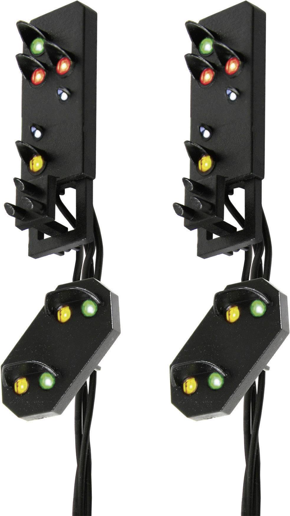 Deux signaux ferroviaires noirs à modèle réduit avec des lumières multicolores sur un fond blanc. À gauche, vert-rouge, à droite, rouge-jaune.