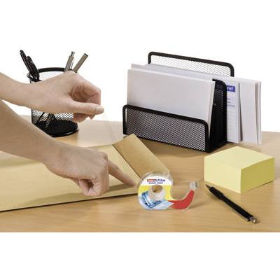 Une personne ferme une enveloppe avec du ruban adhésif sur un bureau où sont posés des stylos, un bloc-notes et un porte-lettres.