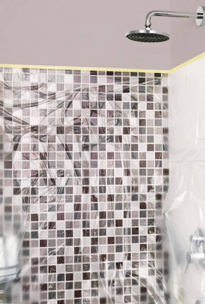 Pommeau de douche au-dessus d'un mur carrelé avec un motif en mosaïque dans des tons neutres. La scène présente un espace de douche moderne et élégant.